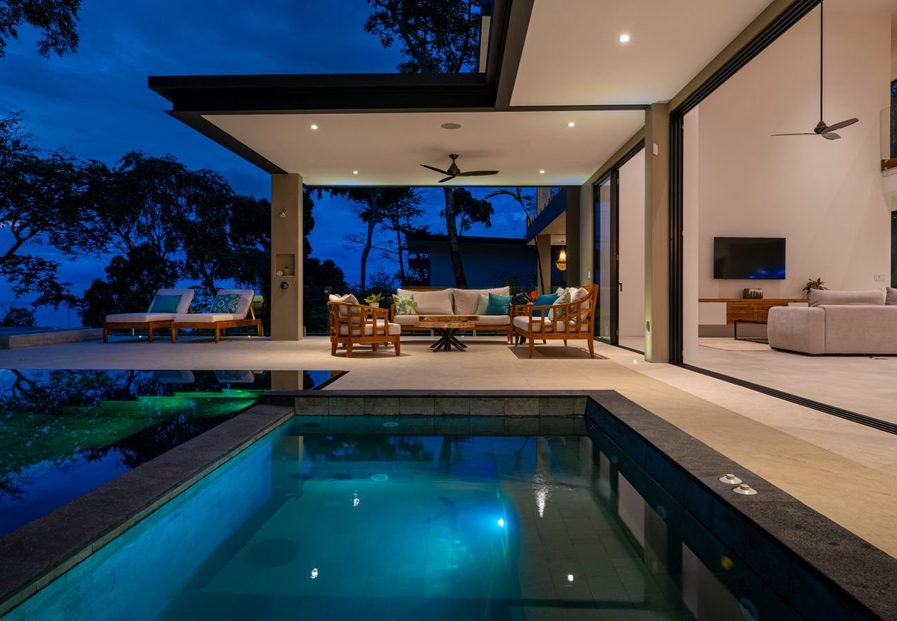 A king suite opening through full-height glass to a private garden terrace