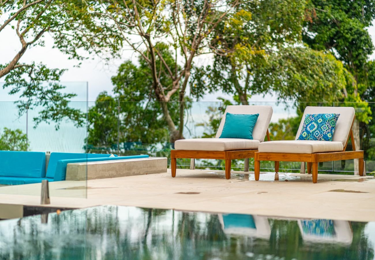 The pool and villa at blue hour, glowing against the evening sky